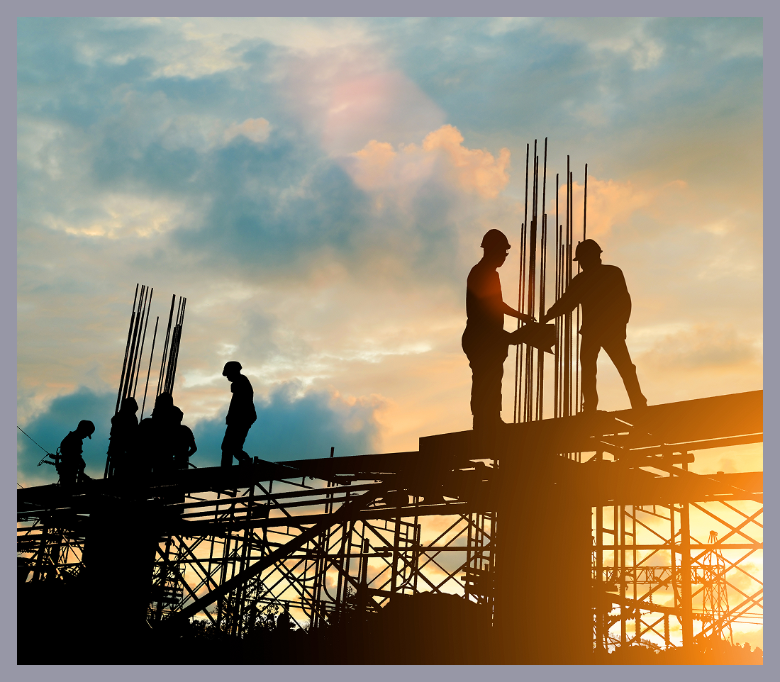 Construction workers silhouetted against sunset sky.